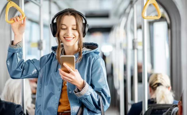 Ein Mädchen in einer Straßenbahn hält ihr Smartphone